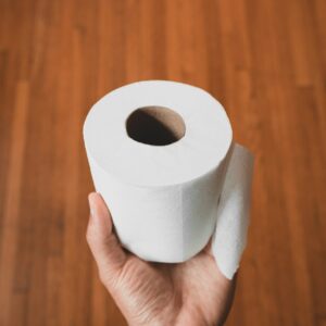 person holding white toilet paper roll