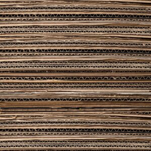 Close-up texture of stacked cardboard for recycling or crafting. Ideal for background use.