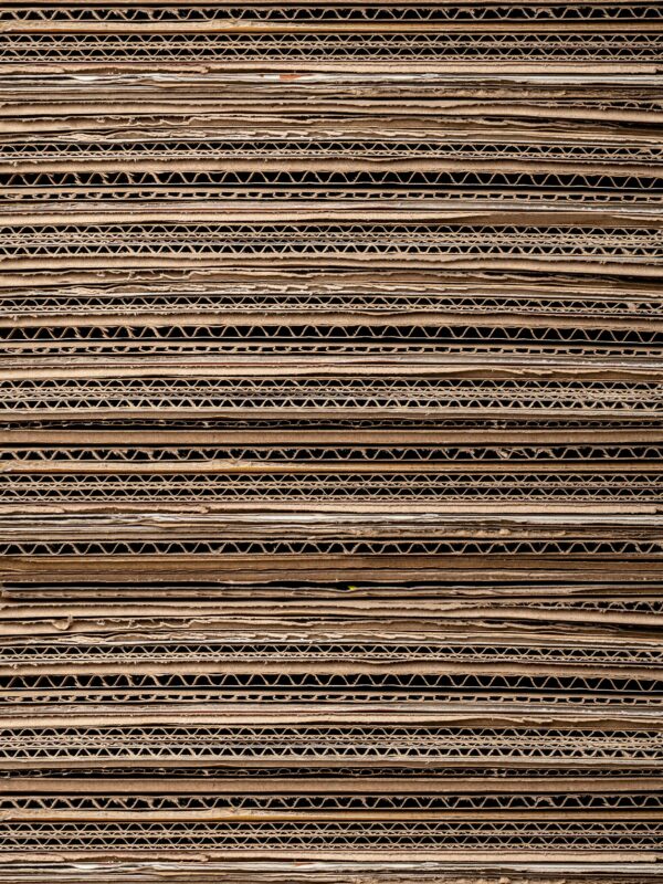 Close-up texture of stacked cardboard for recycling or crafting. Ideal for background use.